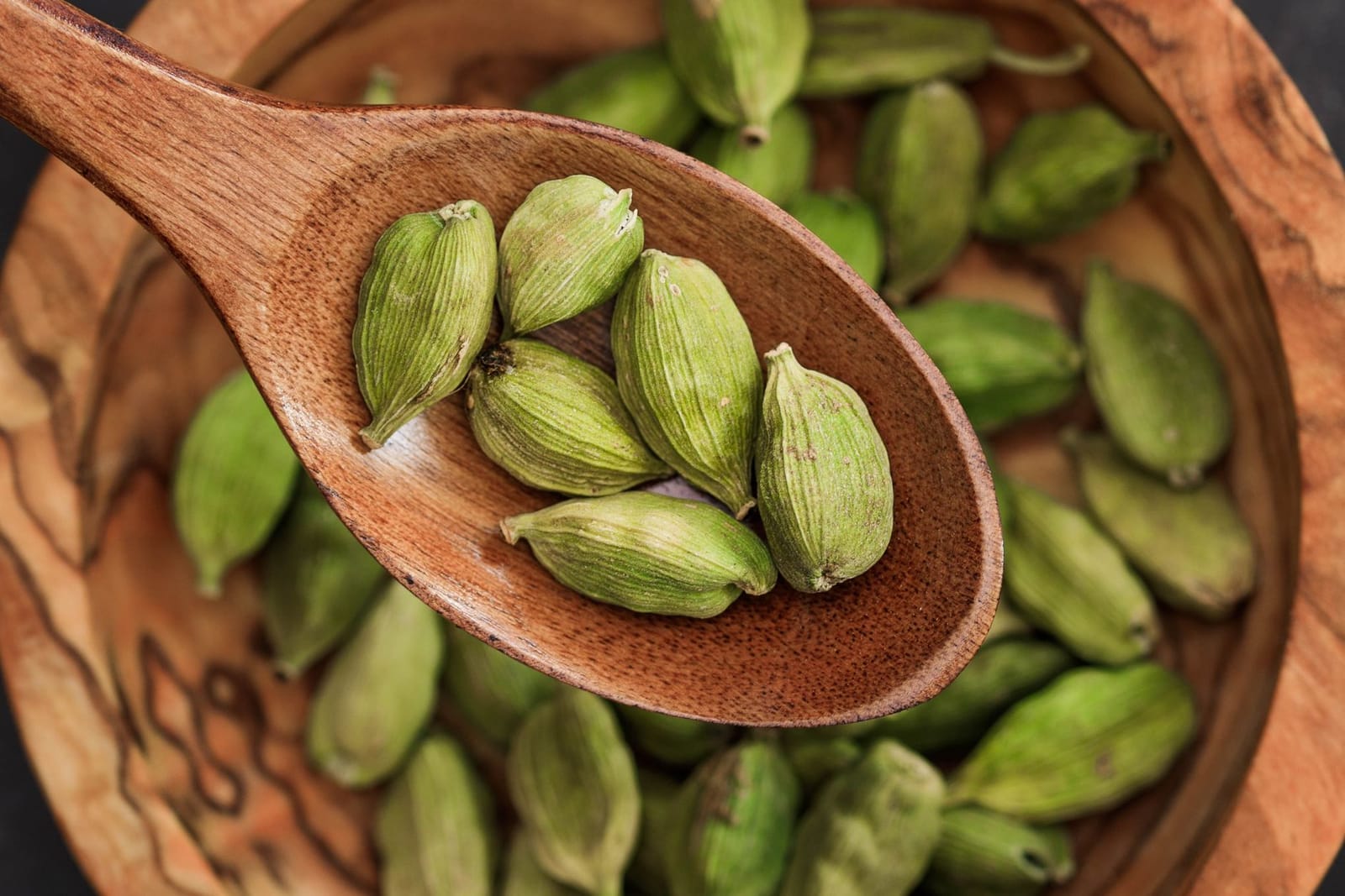Close-up of cardamom pods on wood