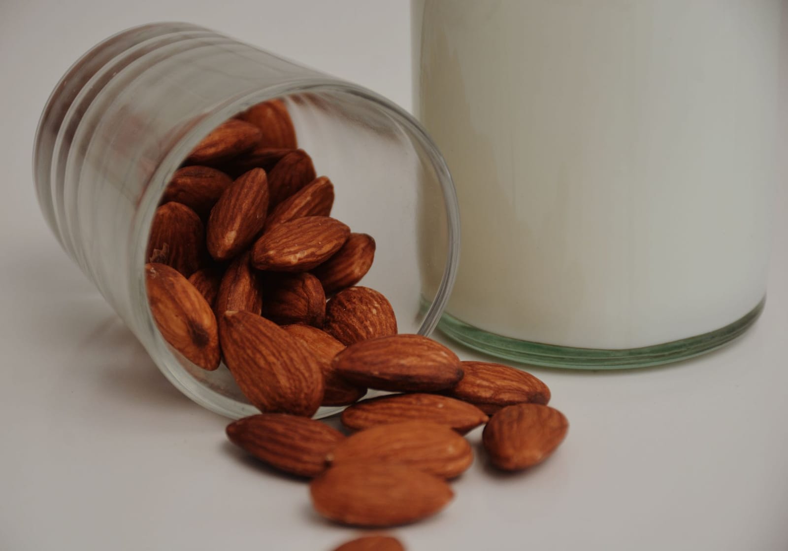 Almond milk in a glass with whole almonds