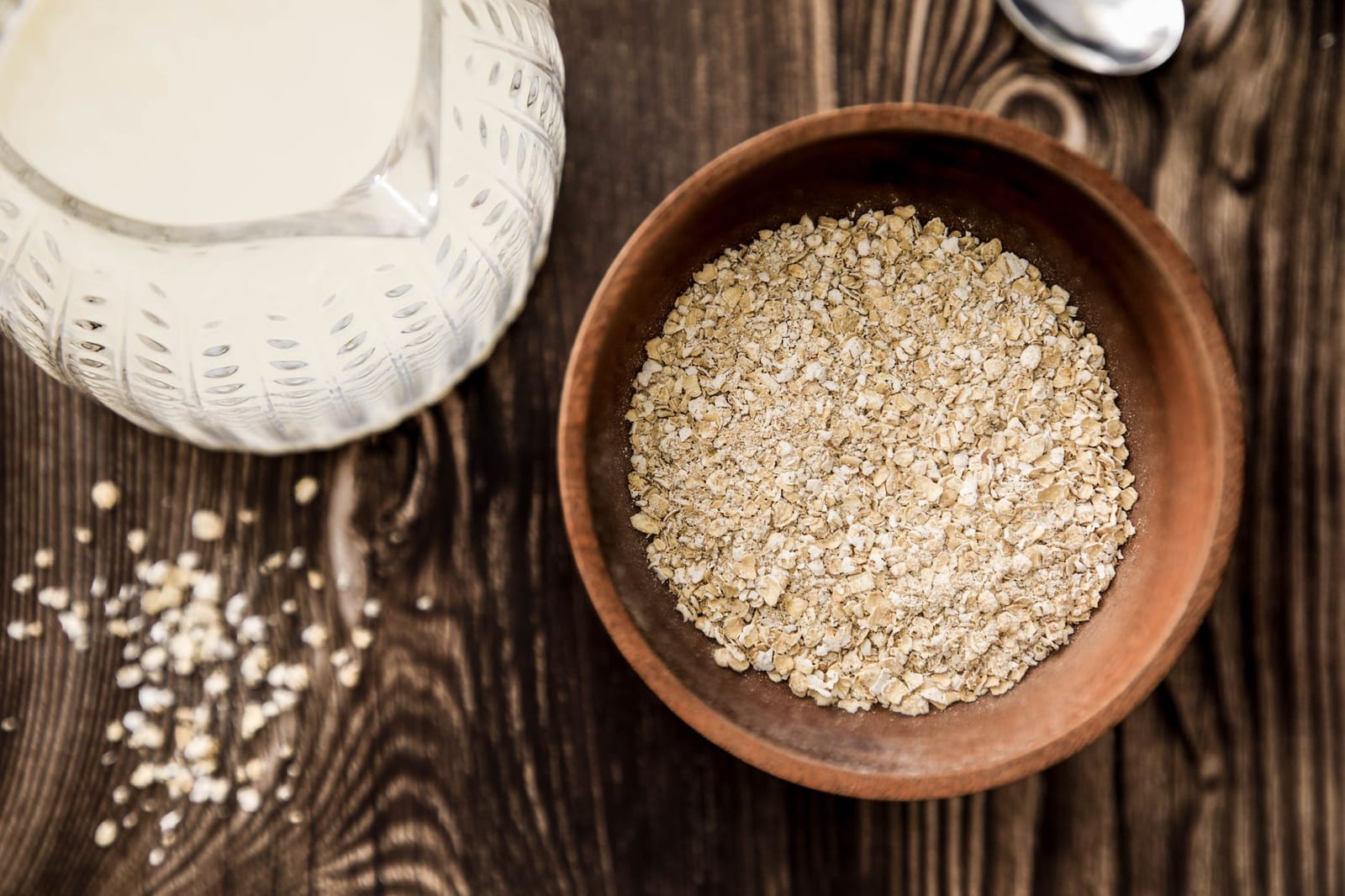 Oat milk in a glass beside rolled oats