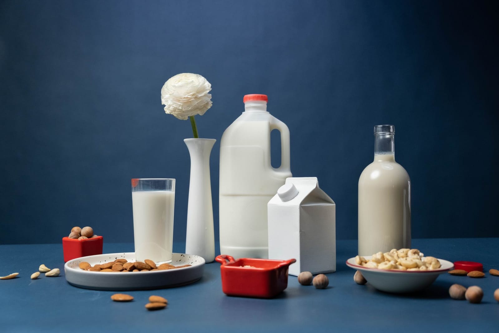 A lineup of plant-based milks in glasses on a table