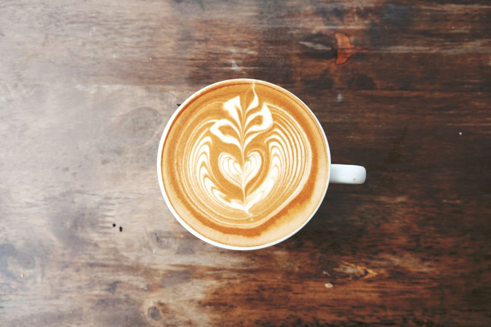 Flat white with leaf latte art at a cafe