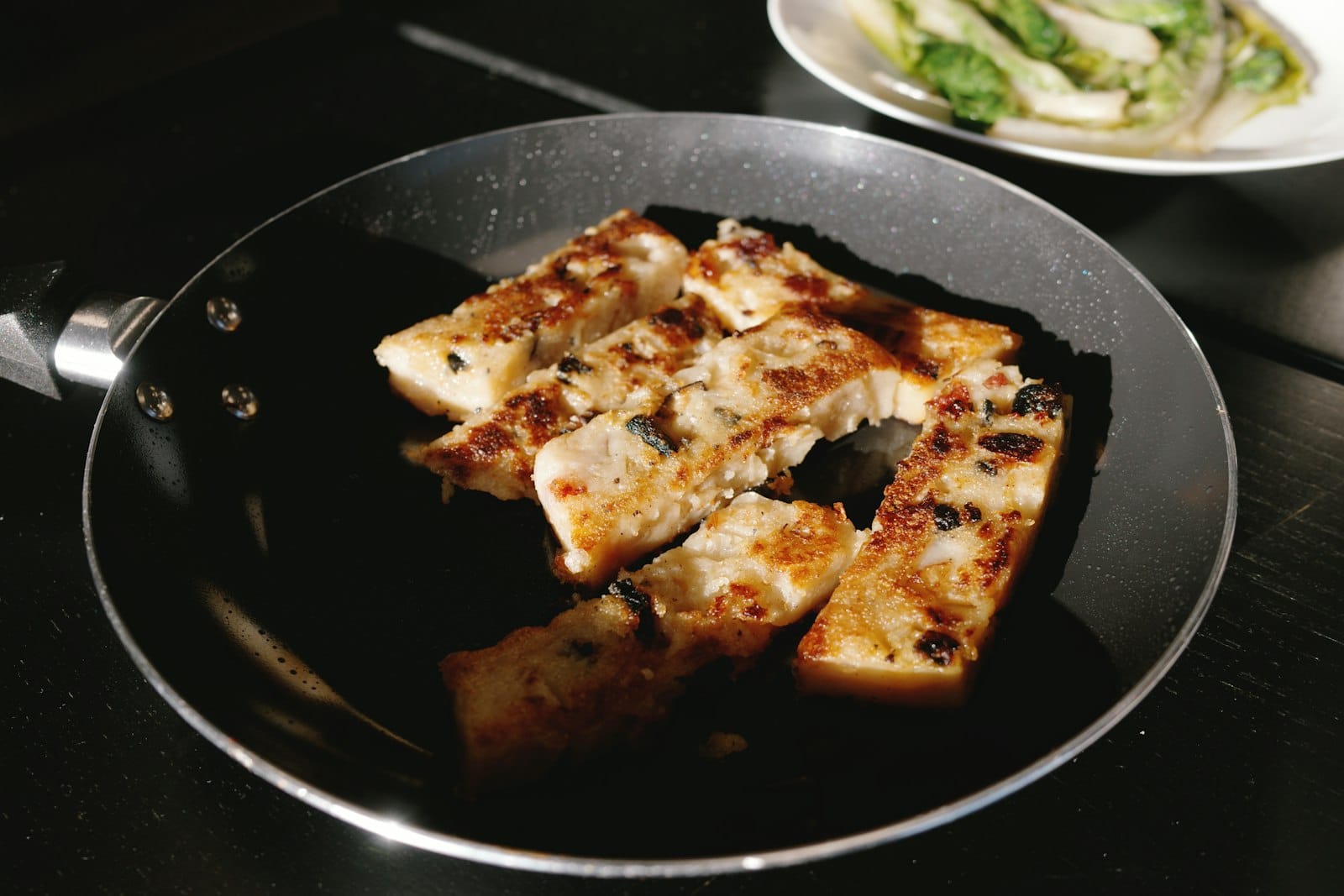 Tempeh cooking in a frying pan
