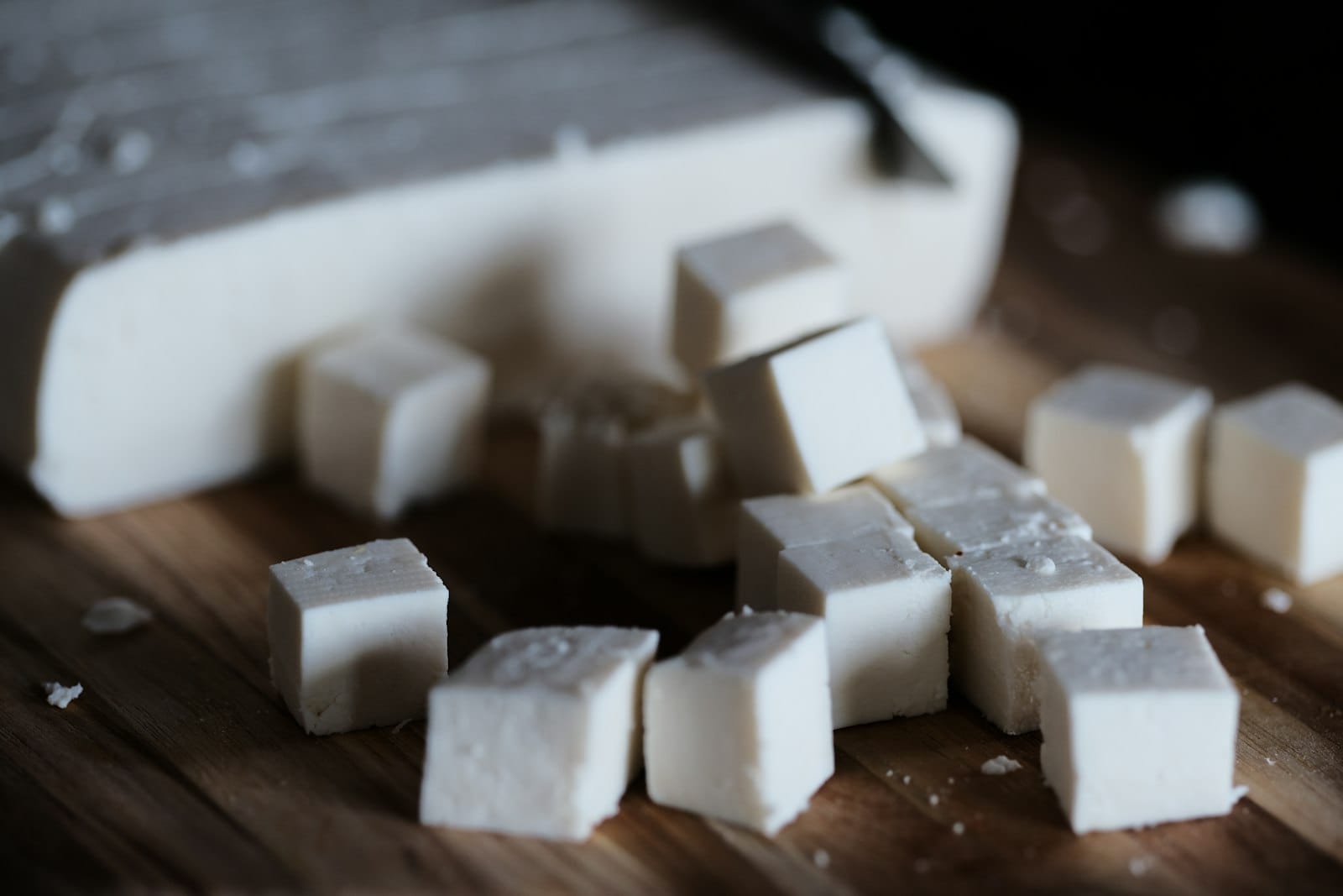 Blocks of firm tofu on a wooden board