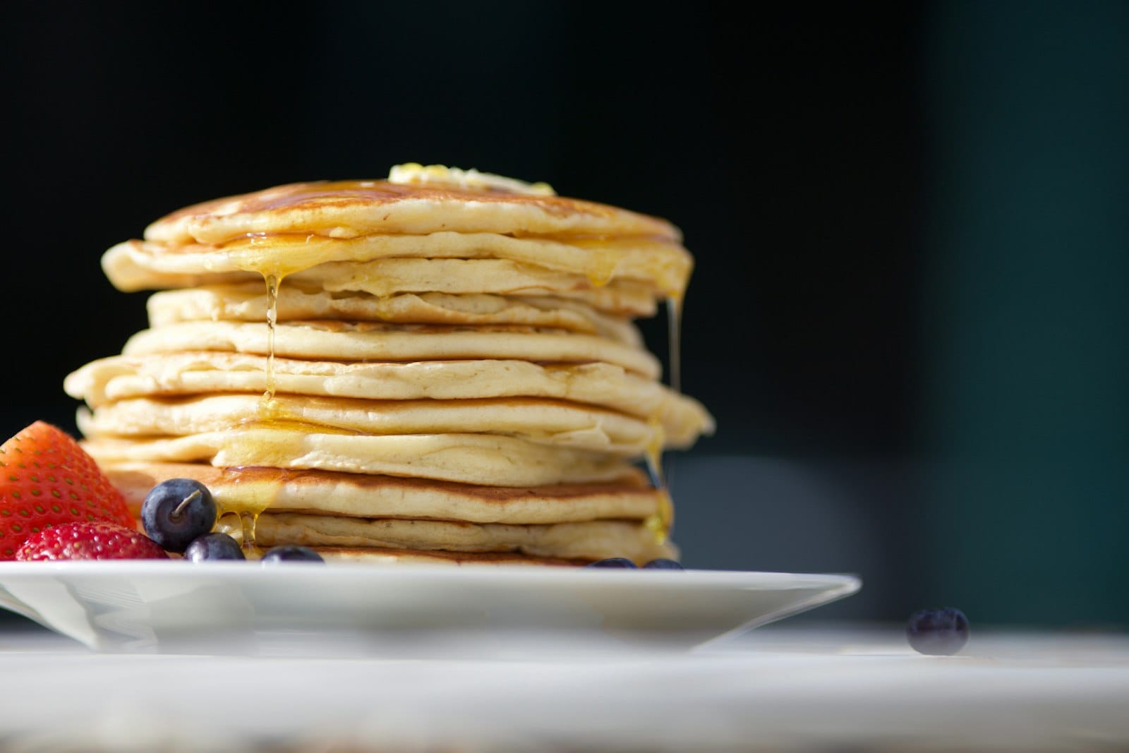 A stack of fluffy vegan pancakes topped with berries