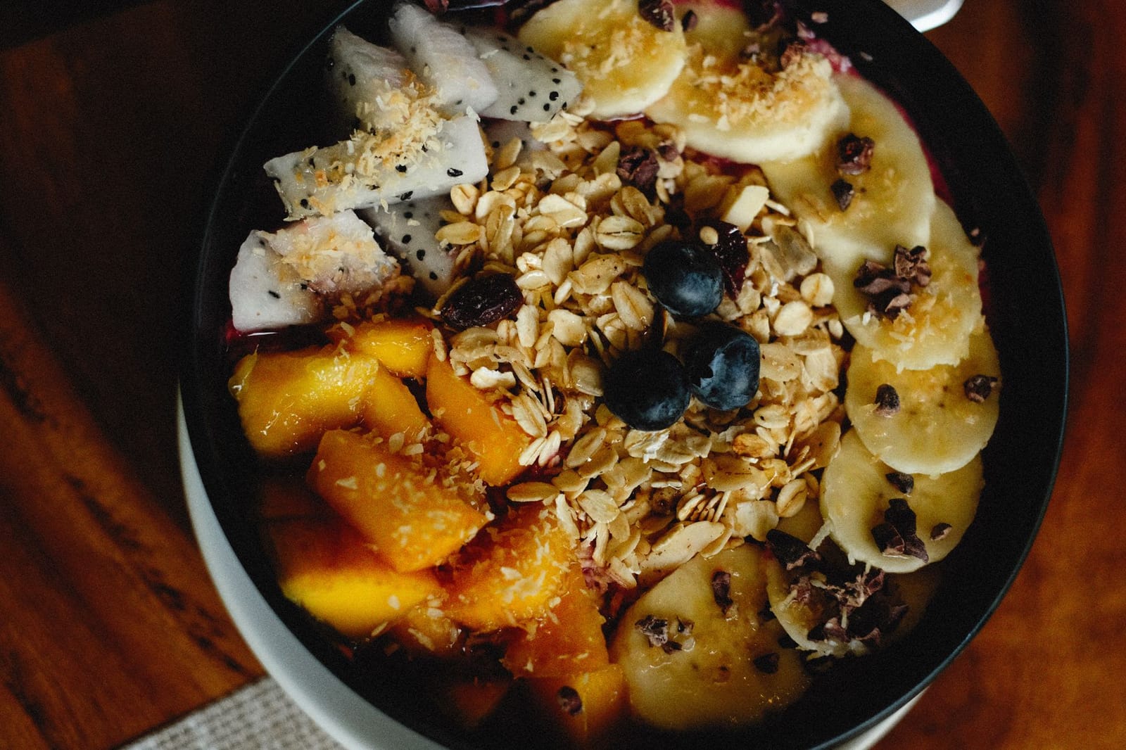 An acai bowl topped with fresh fruit and granola
