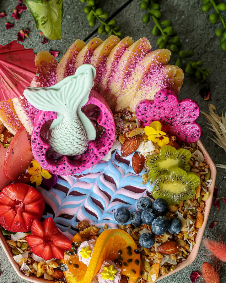 A loaded acai bowl with dragonfruit, kiwi, blueberries, strawberries and granola