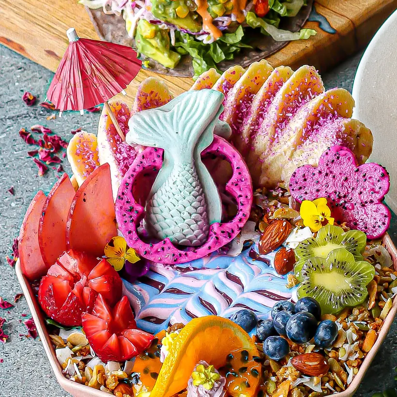 An acai bowl topped with fresh fruit, granola and coconut