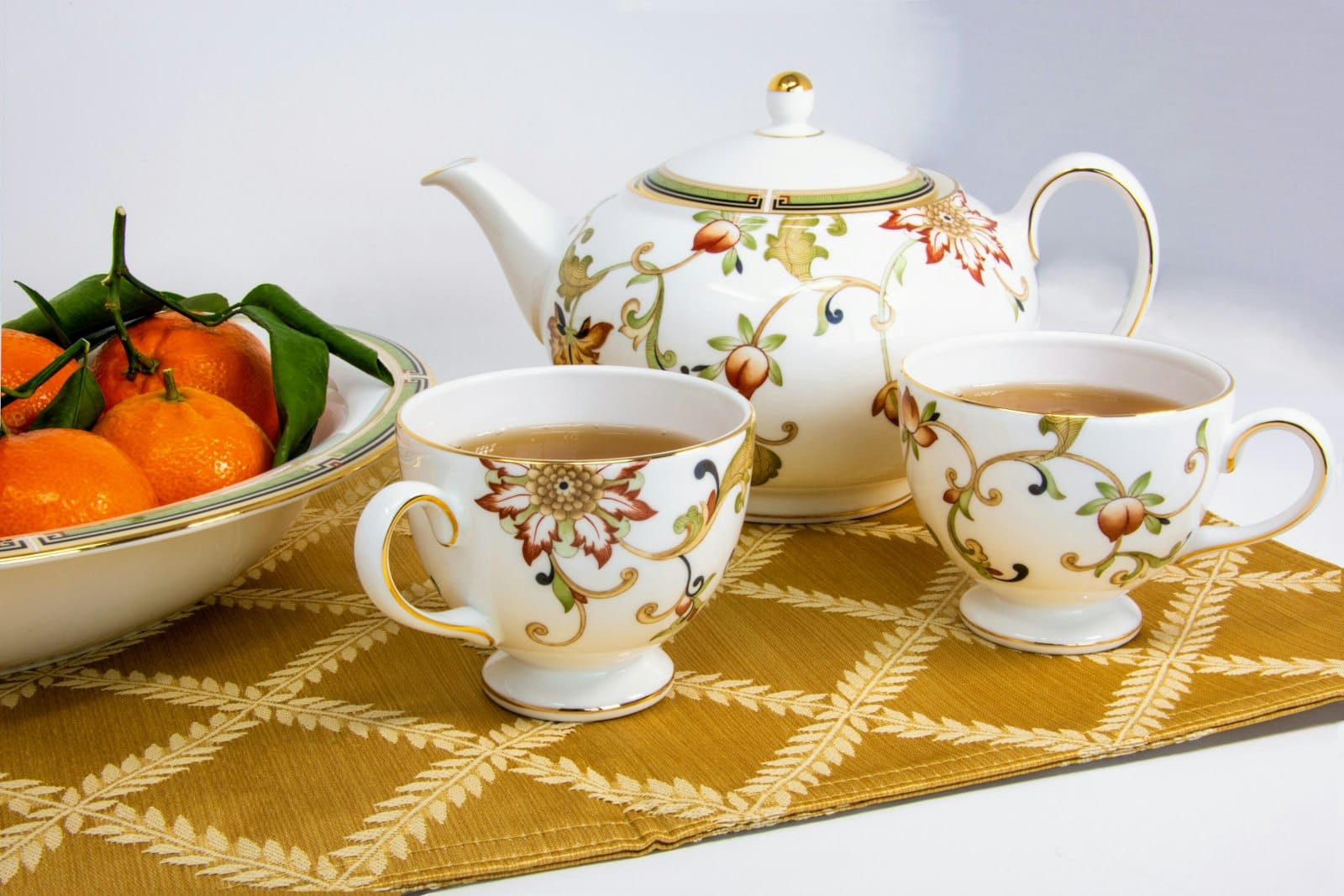 A teapot and cups on an elegant table