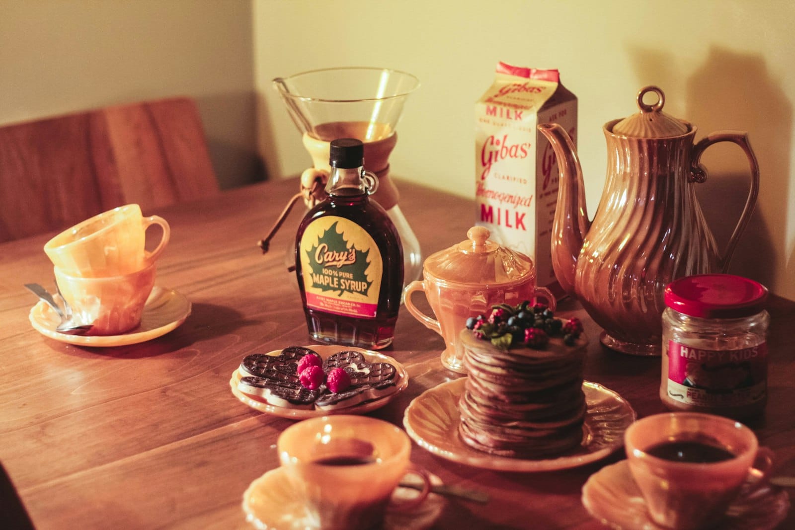 Maple syrup being poured over pancakes