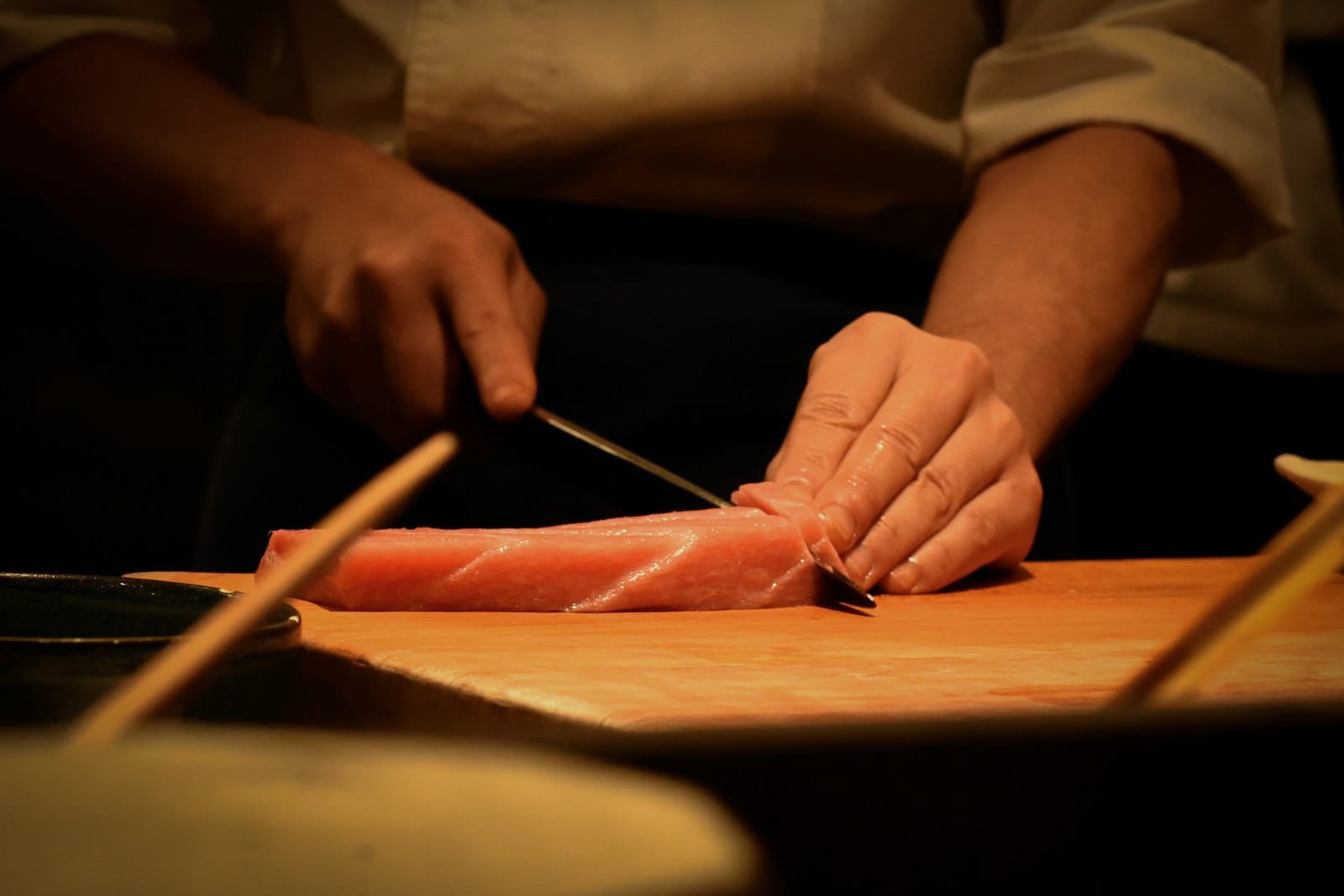 Hands preparing a sushi roll