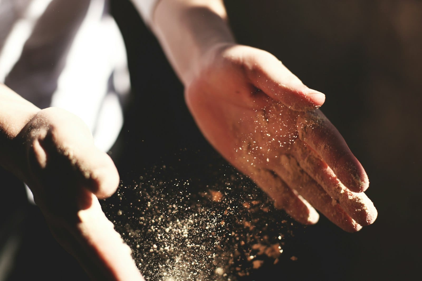 A hand sprinkling spice while cooking